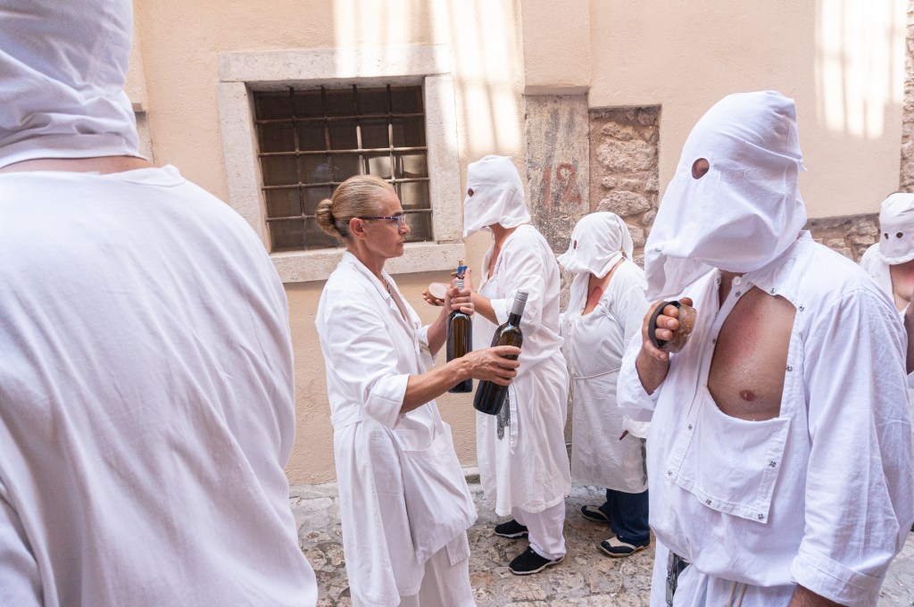 Assistants pouring wine on spugni of battenti during Riti Settennali in Guardia Sanframondi - 2024